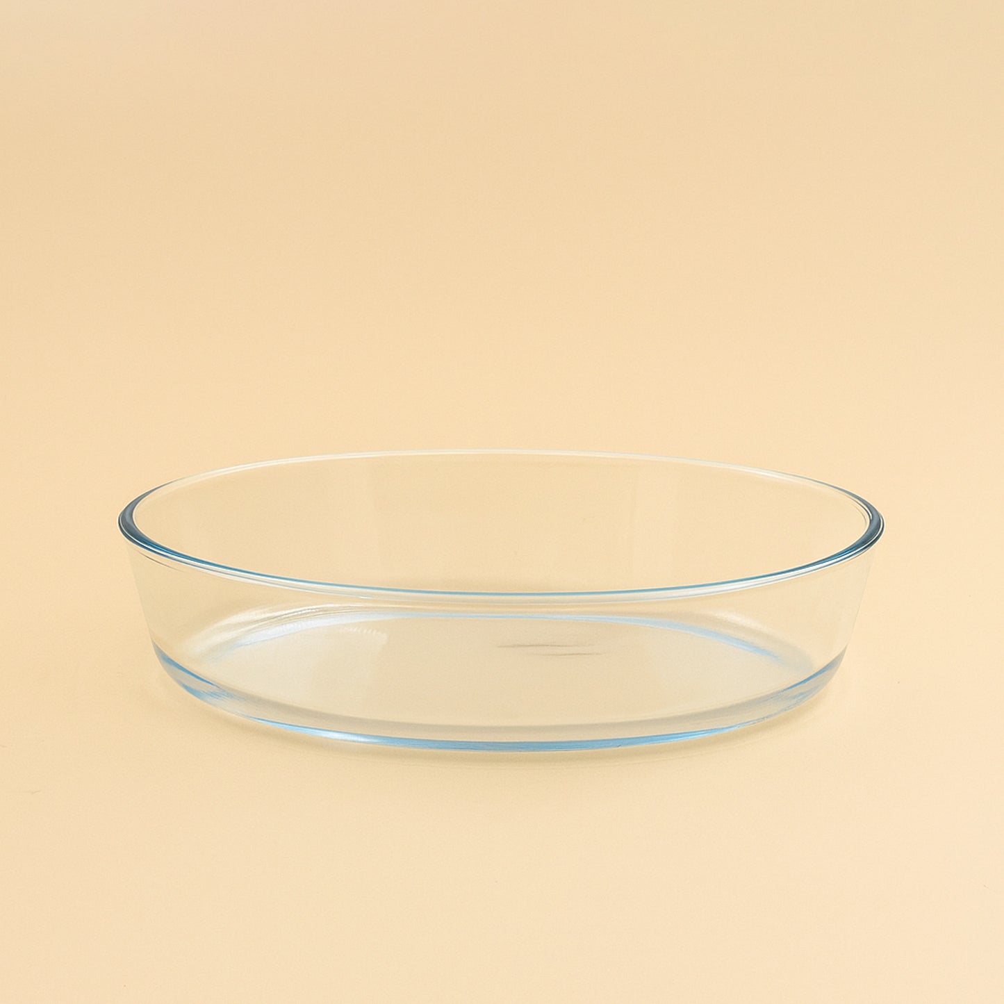 1.6L oval glass baking tray with smooth rim, placed on beige background