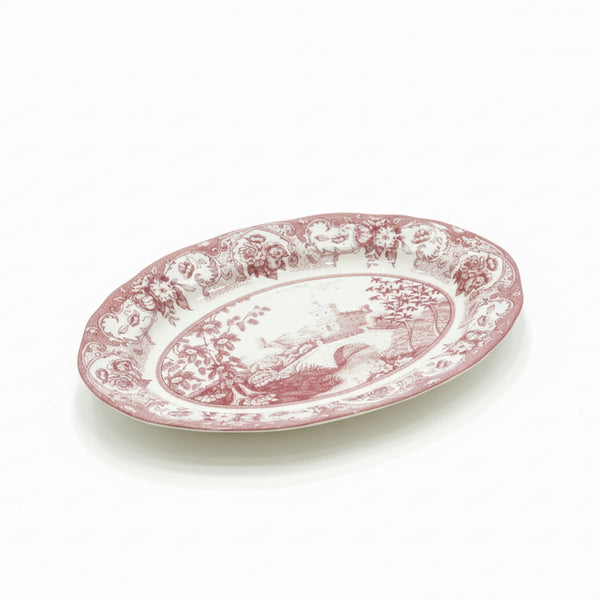 Oval ceramic plate with pink floral design on a white background