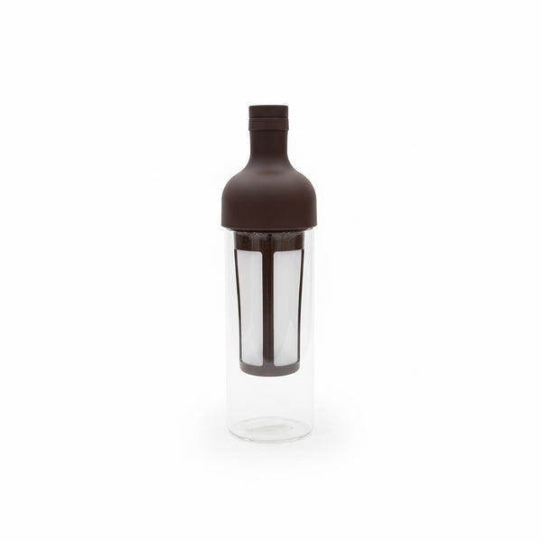 Clear cocktail shaker with brown lid on a white background
