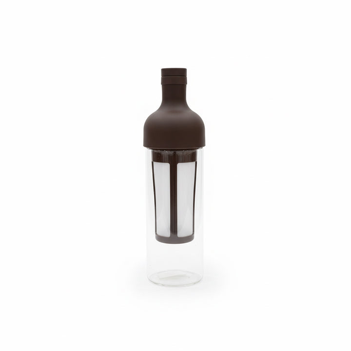 Clear cocktail shaker with brown lid on a white background