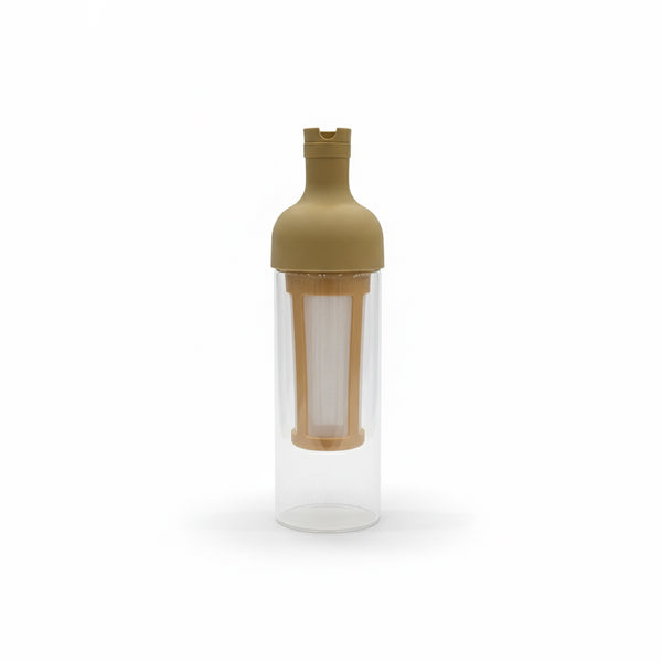 Clear glass bottle with a gold cap and interior filter on a white background
