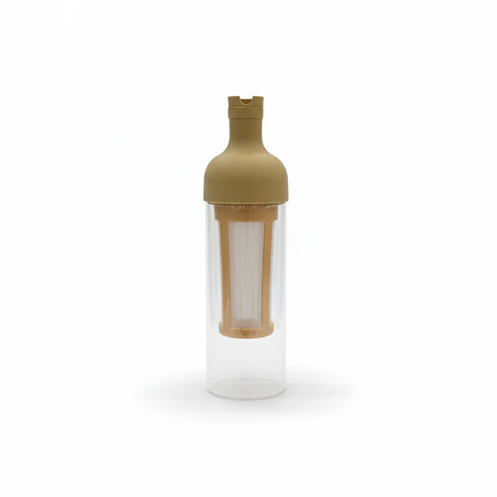 Clear glass bottle with a gold cap and interior filter on a white background