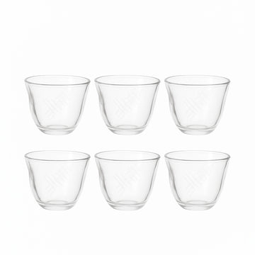 Set of six clear glass tumblers on a white background