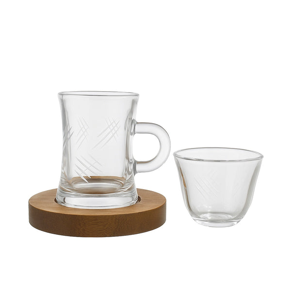 Clear glass mug with wooden coaster and additional clear glass on a white background