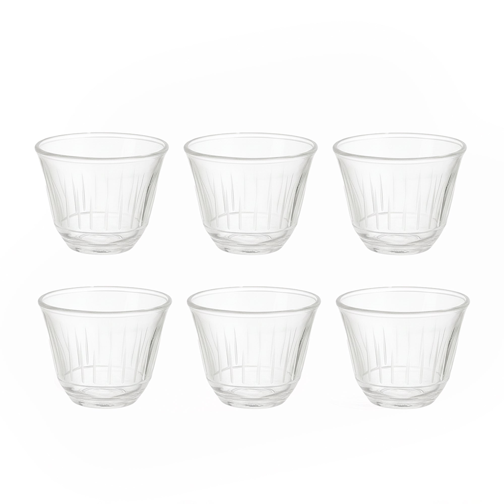 Set of six clear glass tumblers on a white background
