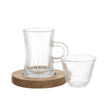 Clear glass carafe and cup on a wooden coaster with a white background