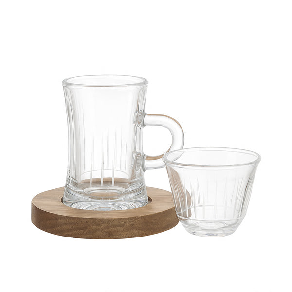 Clear glass carafe and cup on a wooden coaster with a white background