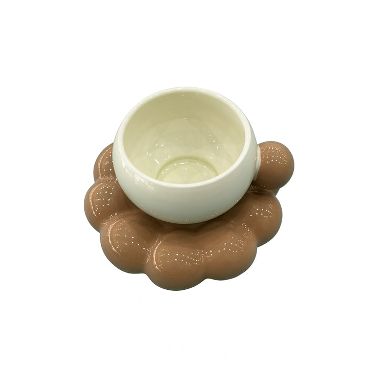 White ceramic bowl on a brown circular base with a textured surface