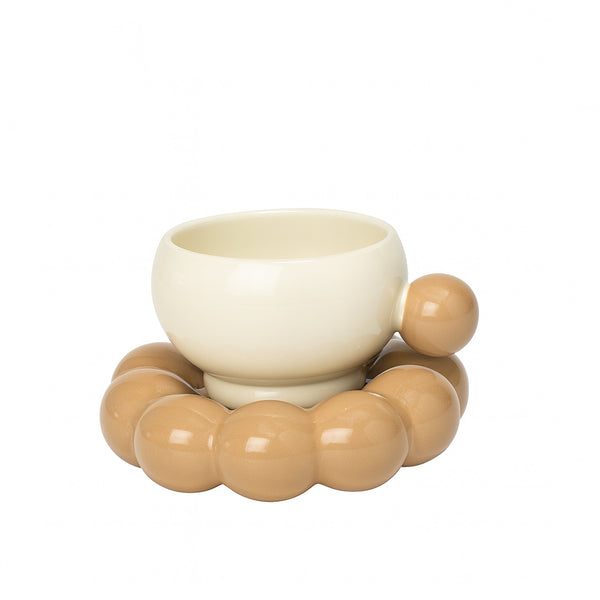 White ceramic bowl with beige ceramic beads on a white background