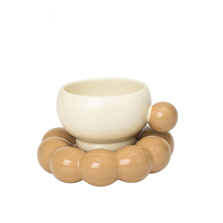 White ceramic bowl with beige ceramic beads on a white background