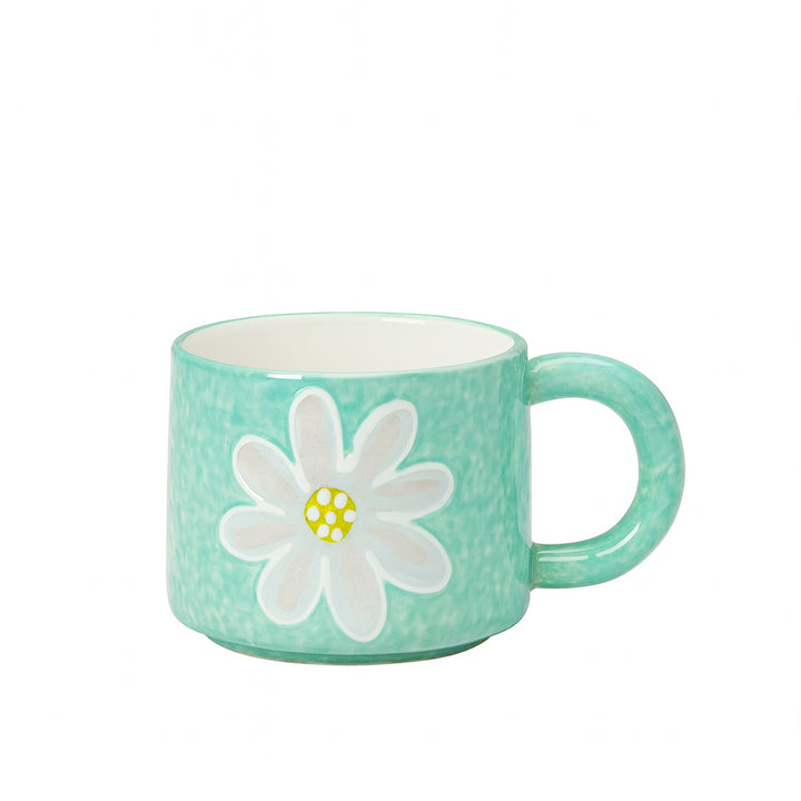 Ceramic cup with a mint green glossy finish featuring a white embossed flower design with a yellow polka-dot center — displayed on a white background from Siddiq Gifts, Mussafah Abu Dhabi.