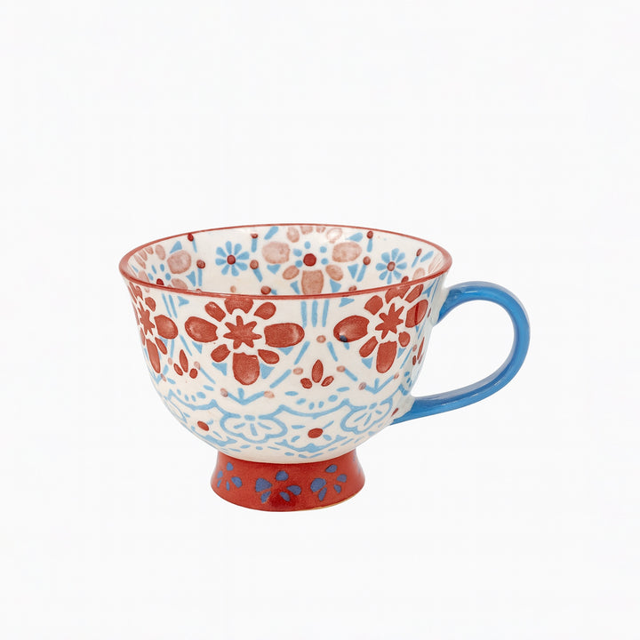 Decorative ceramic cup with floral pattern on a white background