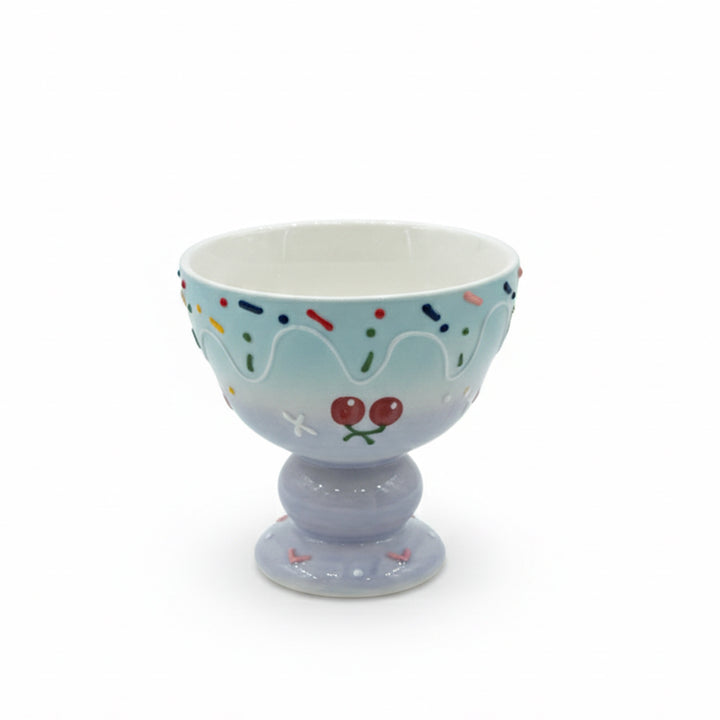 Decorative ceramic bowl with a blue base and white top on a white background