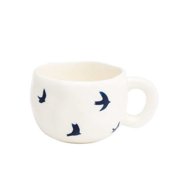 Ceramic cup with a smooth white finish featuring a blue bird pattern and a rounded handle — displayed on a white background from Siddiq Gifts, Mussafah Abu Dhabi.