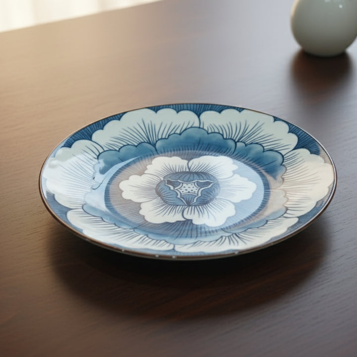 Decorative ceramic plate with floral design on a wooden surface