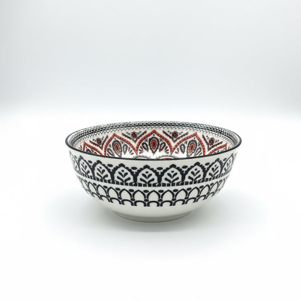 Decorative ceramic bowl with intricate black and red patterns on a white background