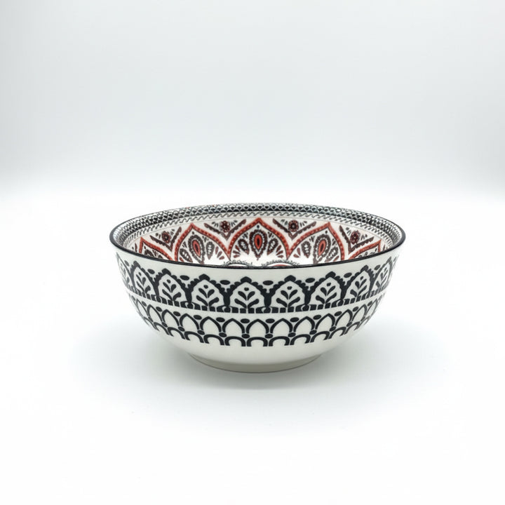 Decorative ceramic bowl with intricate black and red patterns on a white background
