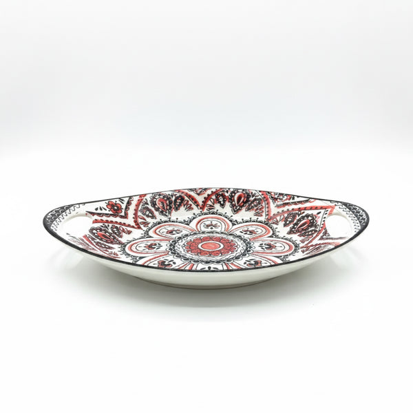 Decorative plate with red and black patterns on a white background