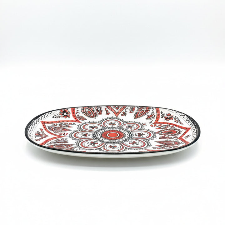 Decorative plate with red and black pattern on a white background