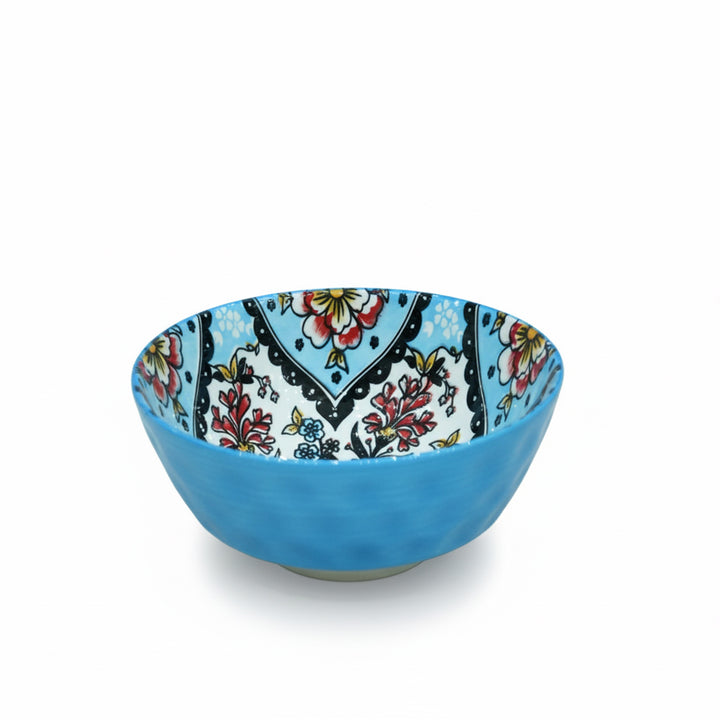 Blue ceramic bowl with colorful floral pattern on a white background