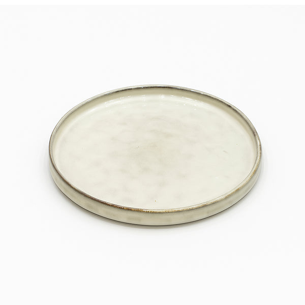 Round ceramic plate with a beige glaze on a white background