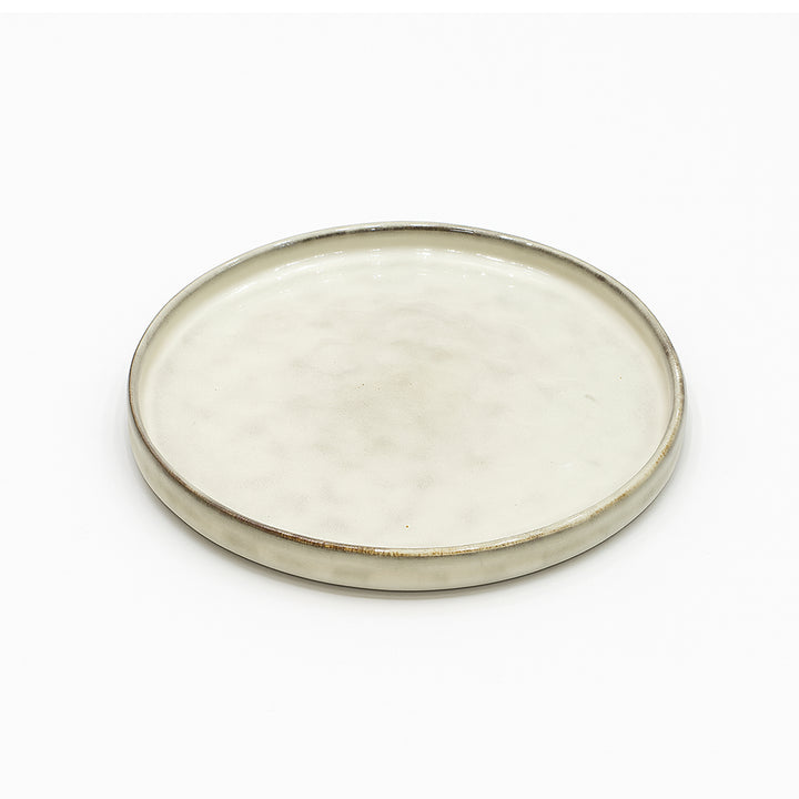 Round ceramic plate with a beige glaze on a white background