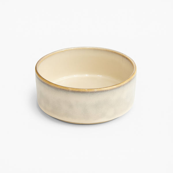 Beige ceramic bowl with gold rim on a white background