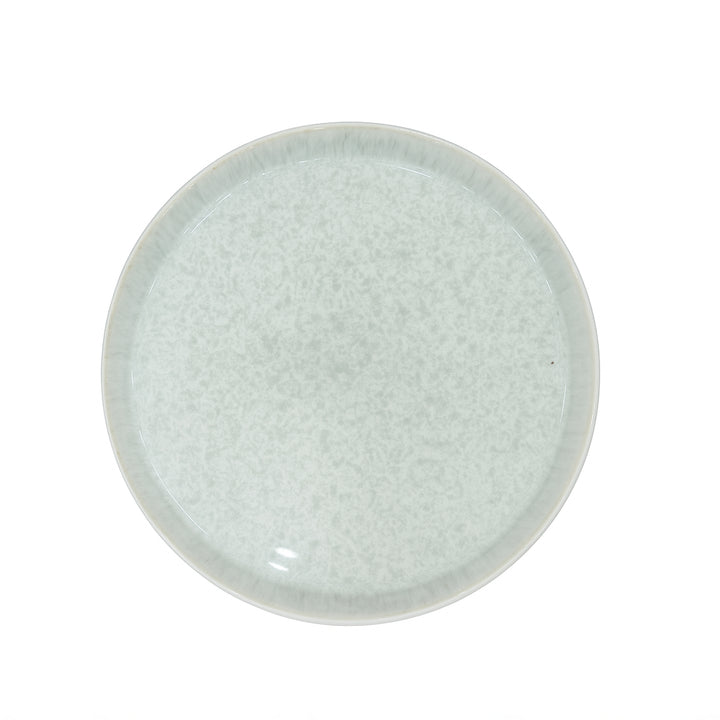 Round ceramic plate with textured surface on a white background