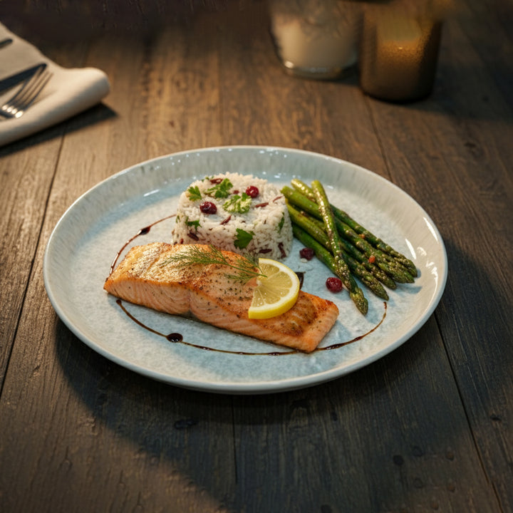 Plated dish of salmon with asparagus and rice on a wooden table