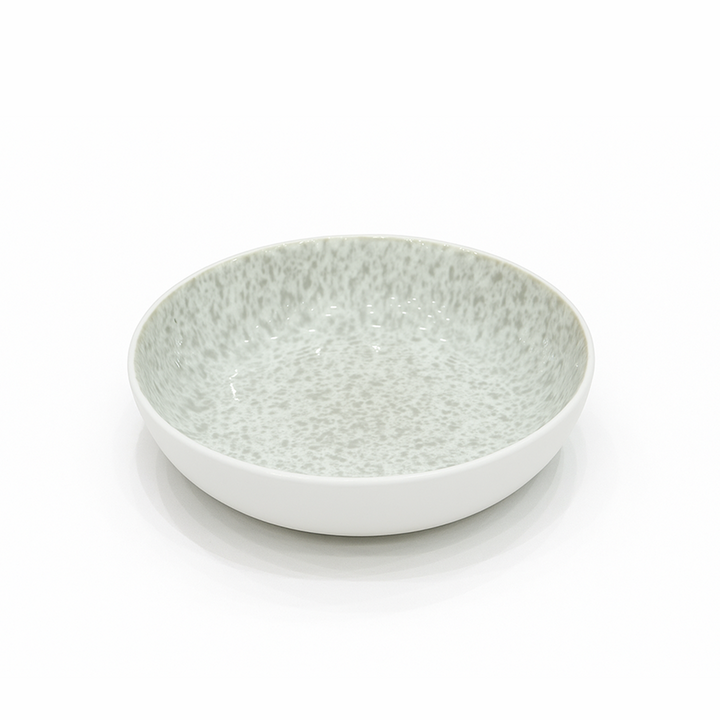 White ceramic bowl with speckled pattern on a white background