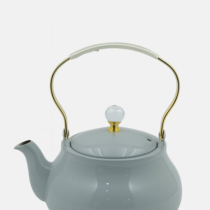 Light blue teapot with gold handle on a white background


