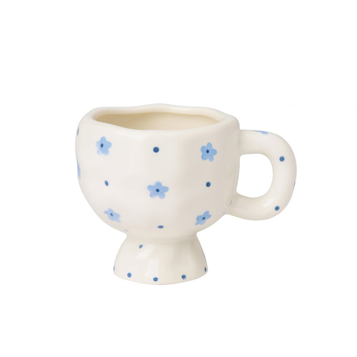 Ceramic mug with a white finish featuring a delicate blue floral pattern and rounded handle, displayed on a white background — 9 cm design from Siddiq Gifts, Mussafah Abu Dhabi.
