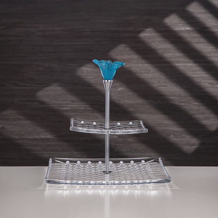 Glass display stand with blue top section on a reflective surface with a dark background