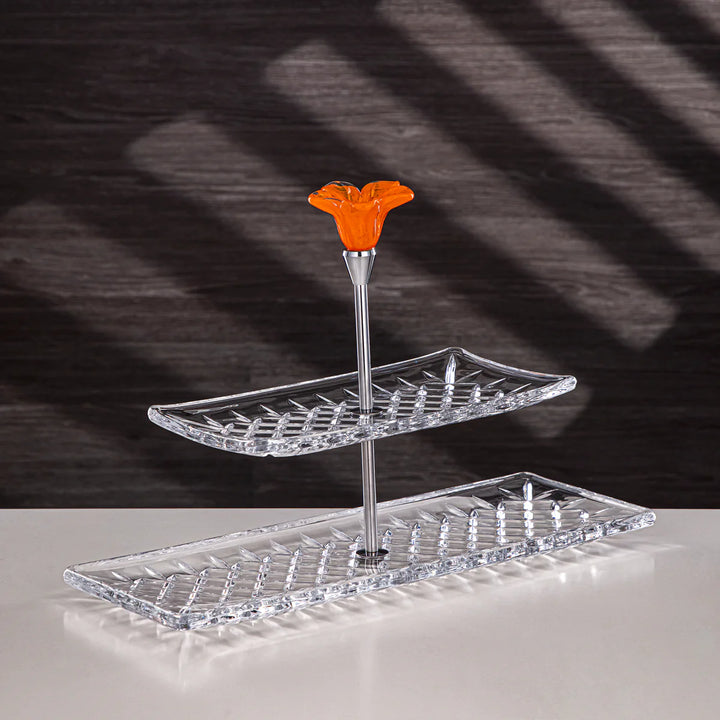 Two-tiered clear tray with an orange flower-shaped top piece on a dark background