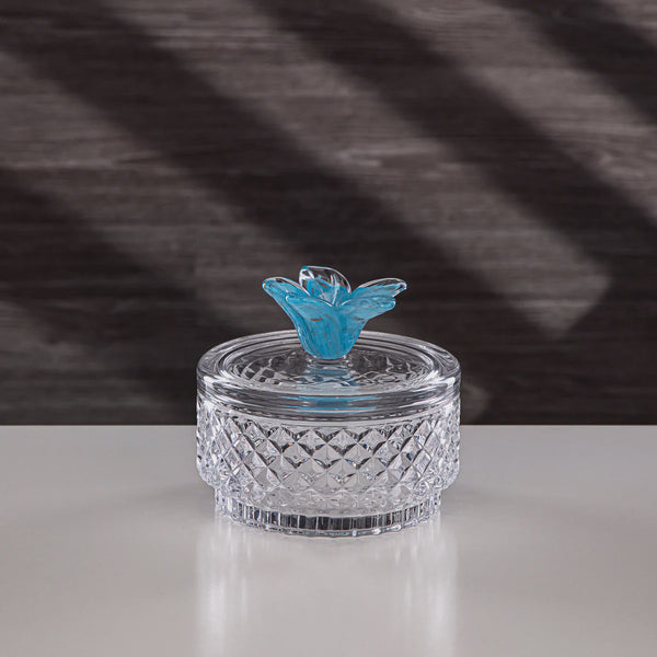 Clear glass container with a blue butterfly on a checkered fabric background
