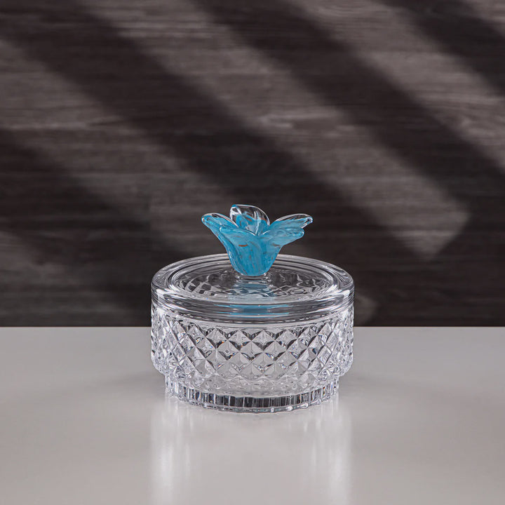 Clear glass container with a blue butterfly on a checkered fabric background