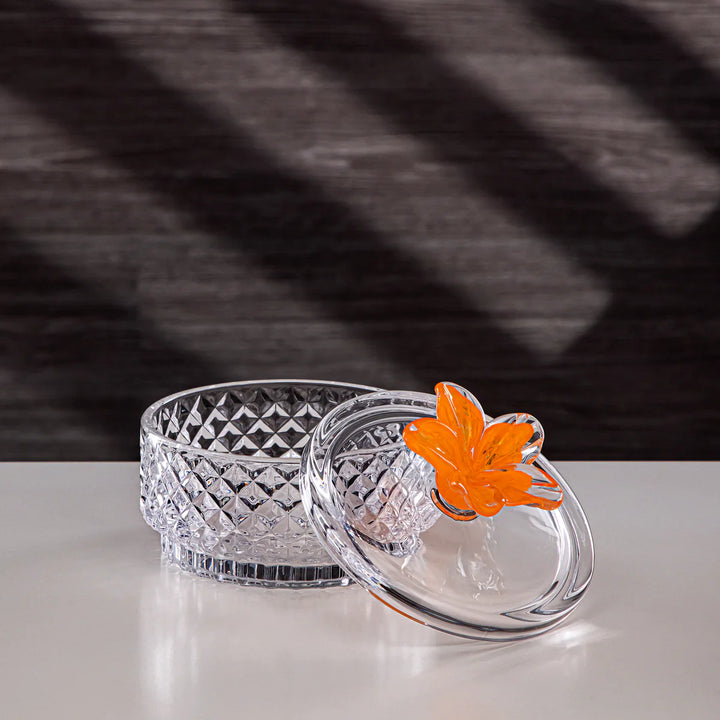 Clear glass bowl with an orange butterfly decoration on a dark background