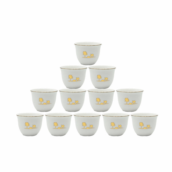 Set of twelve small white cups with gold floral designs on a white background