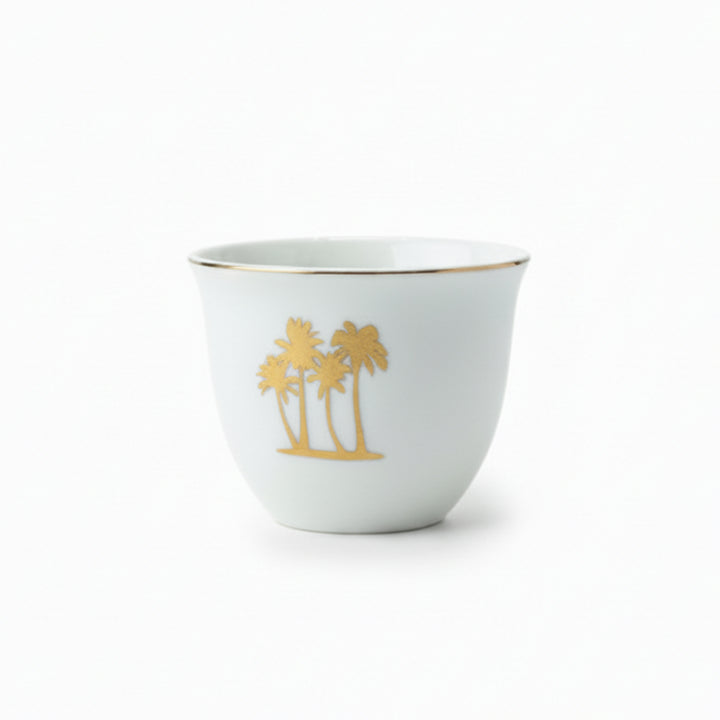 White ceramic cup with gold palm tree design on a white background