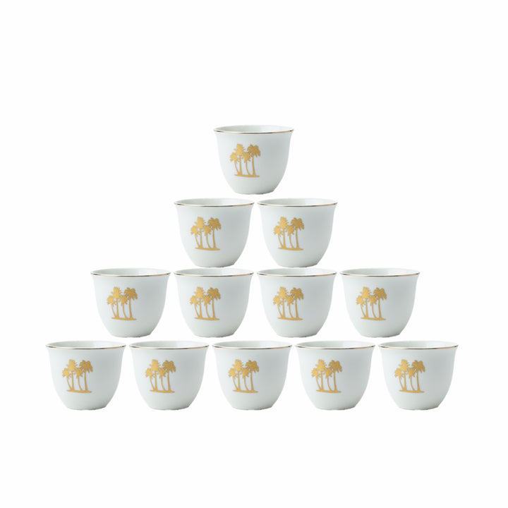 Set of twelve white cups with gold palm tree design on a white background