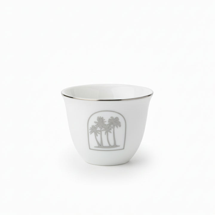 White ceramic cup with palm tree design on a white background
