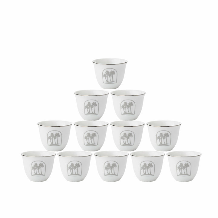 Set of twelve white ceramic cups with a decorative emblem on a white background