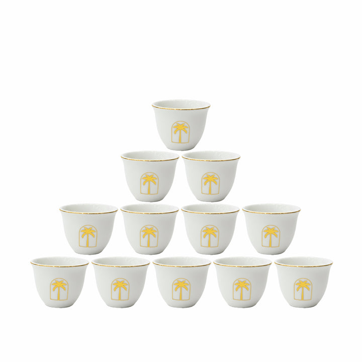 Set of 12 white cups with gold palm tree design on a white background