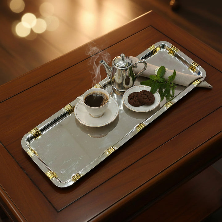 Silver tray with a cup of coffee, cookies, and a teapot on a wooden surface.