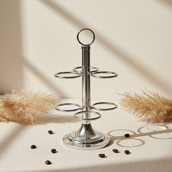 Silver three-tiered stand on a neutral background with scattered coffee beans