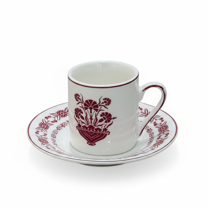 Ceramic cup and saucer with red floral design on a white background
