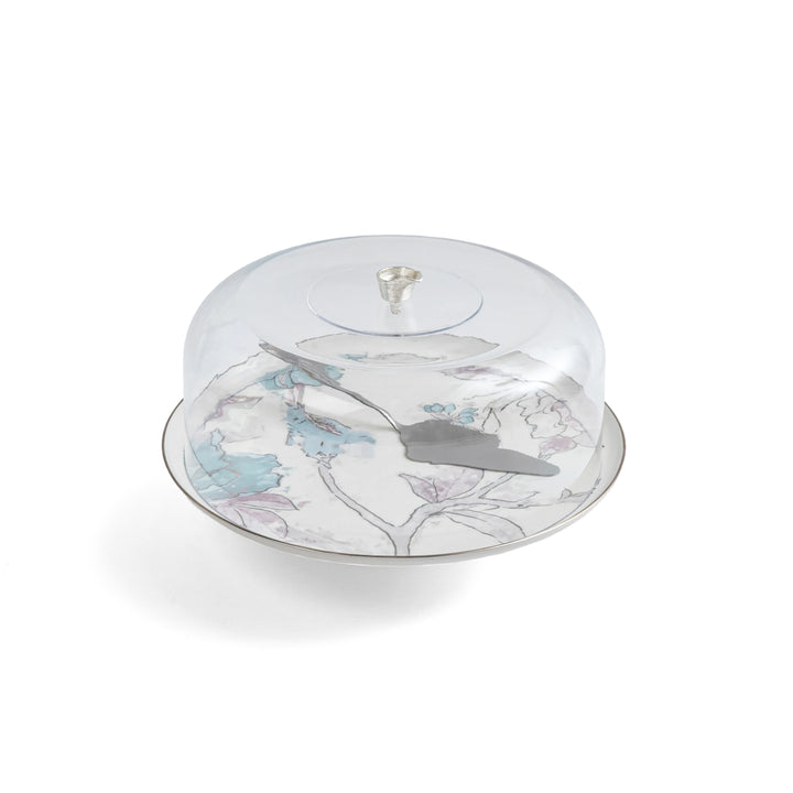 Decorative cake stand with floral design and clear dome cover on a white background