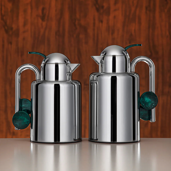Two silver jugs with green accents on a white background
