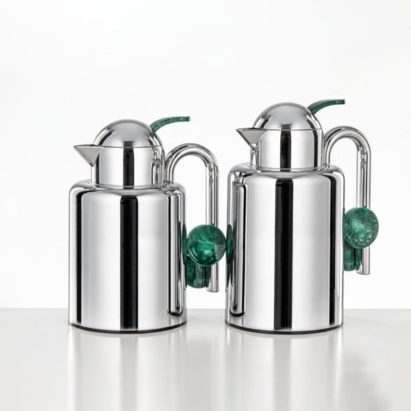 Two silver jugs with green accents on a white background