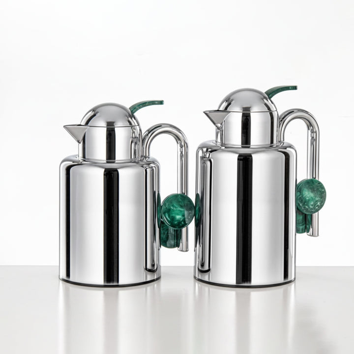 Two silver jugs with green accents on a white background